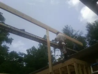 Carpenter setting a ridge beam over a new addition frame — Ice Dam Removal by Roofing Brothers in Alamo